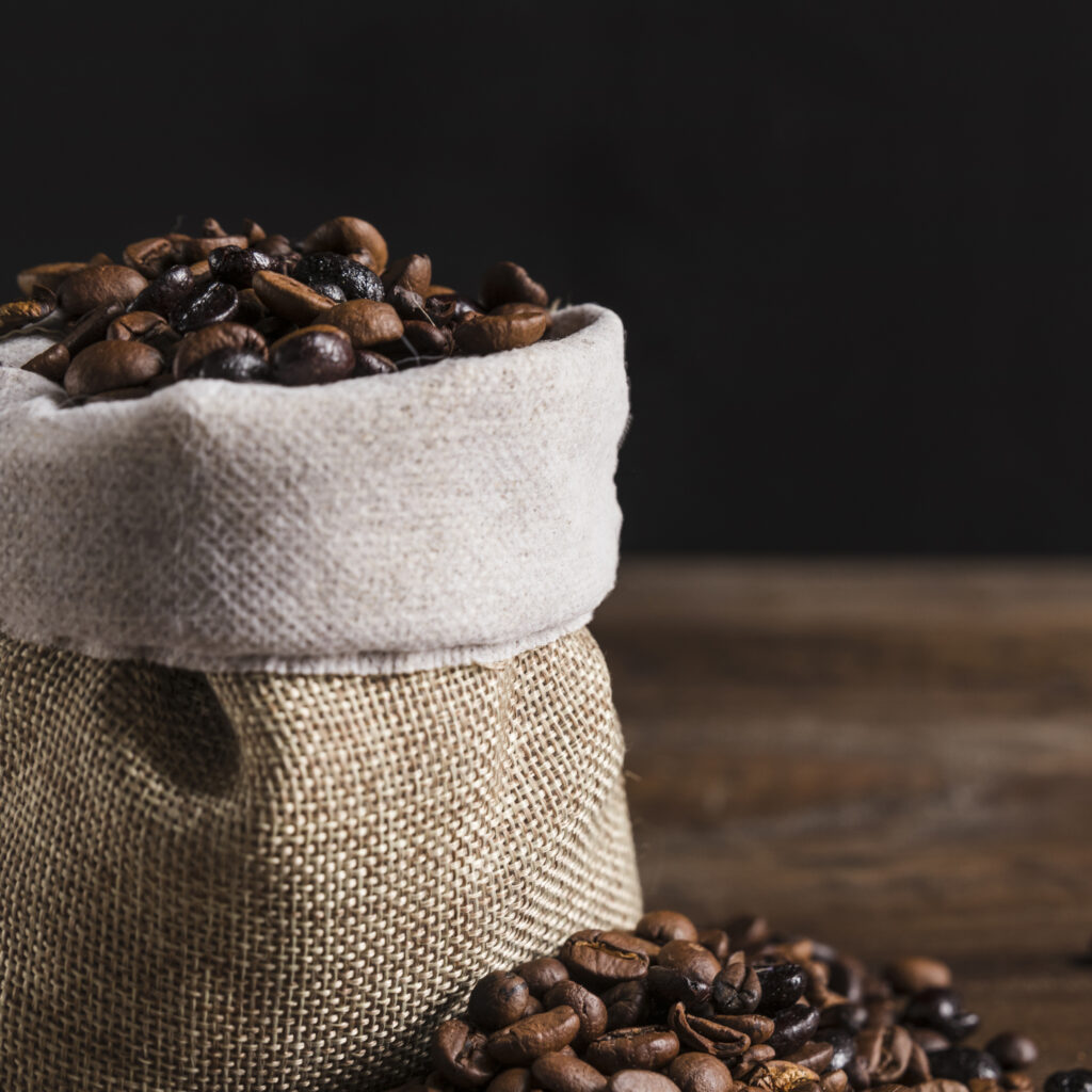 graos de cafe na bolsa e na mesa 1